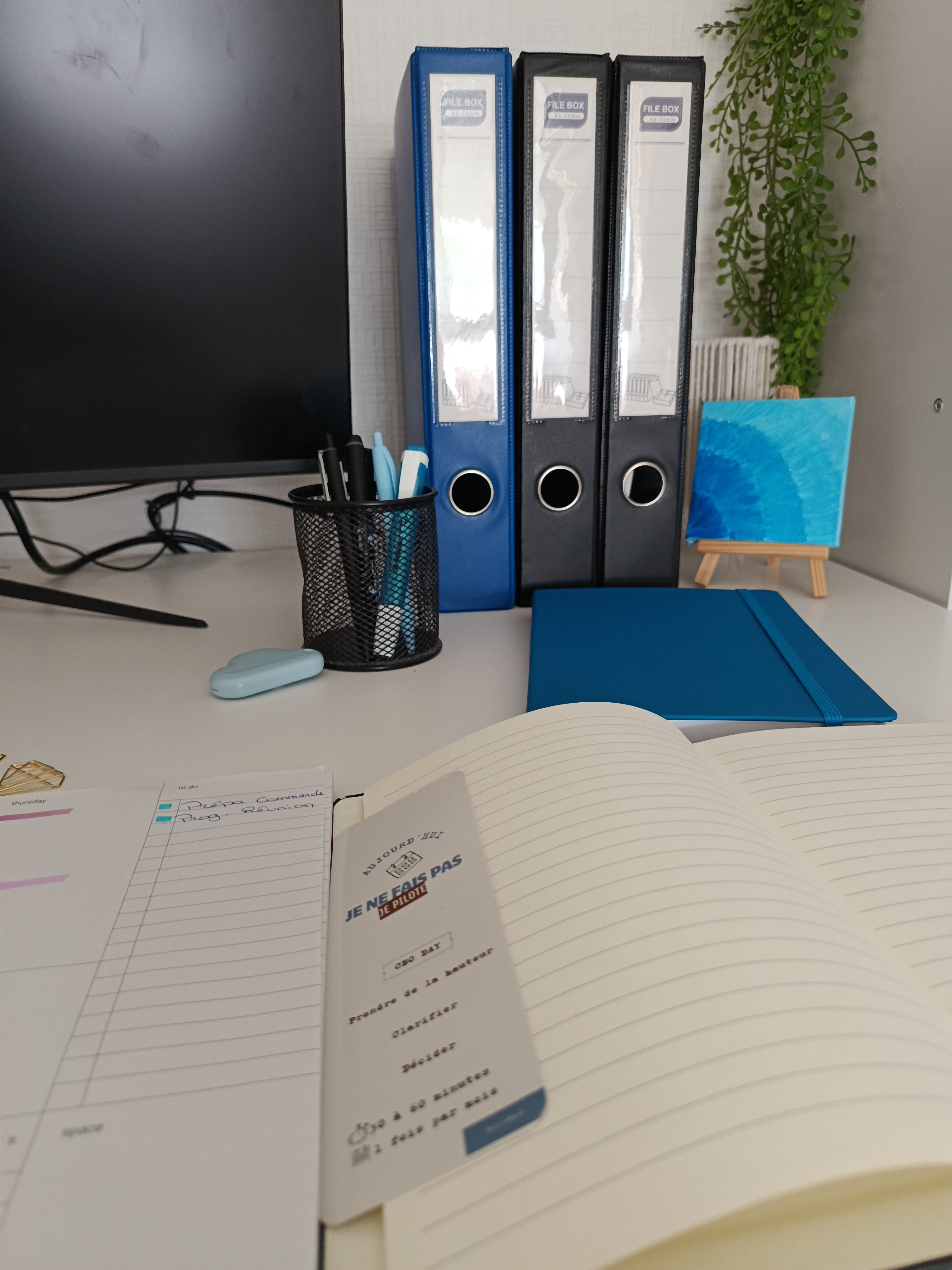 Bureau avec classeurs bleus et carnets ouverts