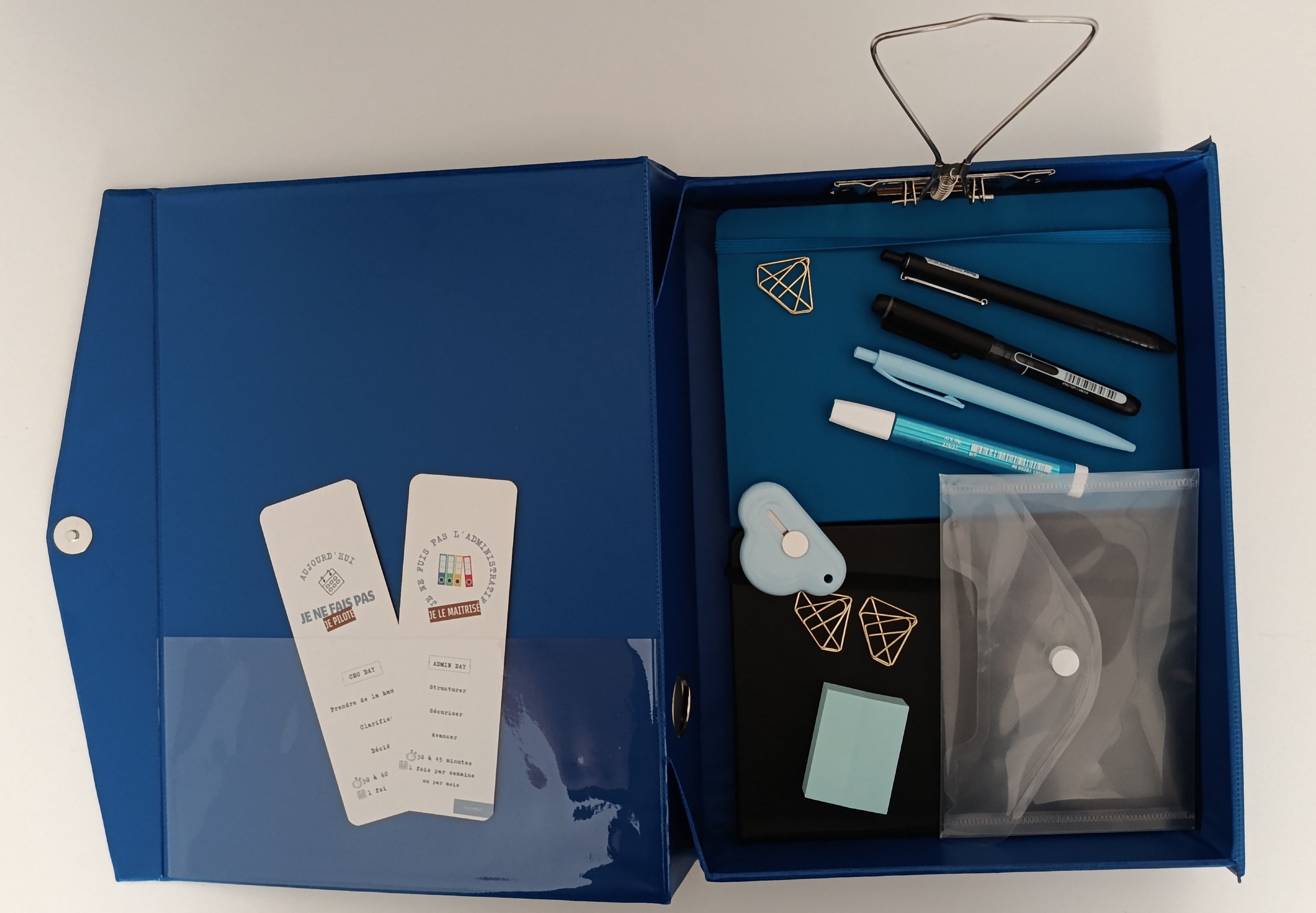Détail intérieur box bleue avec accessoires, trombones dorés et marque-pages